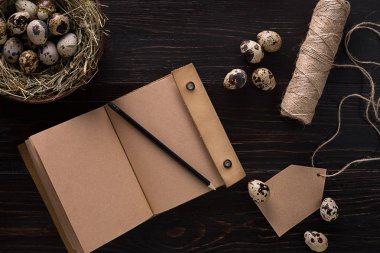 yuva, defter ve siyah bir arka plan iş parçacığında bıldırcın yumurtası