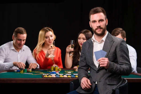 Pokerspieler im Casino mit Karten und Chips auf schwarzem Hintergrund — Stockfoto