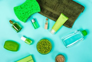 Spa set: sabun, maske, petrol, deniz tuzu ve havlu mavi zemin üzerine