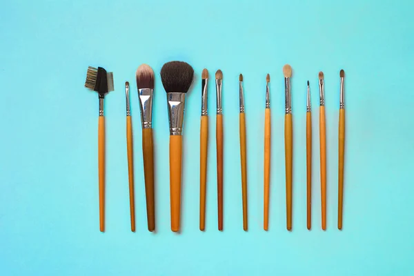 Inventa o essencial. Conjunto de escovas de maquiagem profissional no fundo azul . — Fotografia de Stock