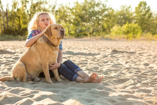 Genç kadın ile onun köpek sahilde
