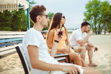 Gençler zevk yaz tatil plaj barda içki güneşlenme