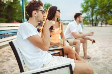 Gençler zevk yaz tatil plaj barda içki güneşlenme
