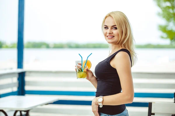 Chica rubia en una terraza de verano en un bar bebidas cóctel —  Fotos de Stock