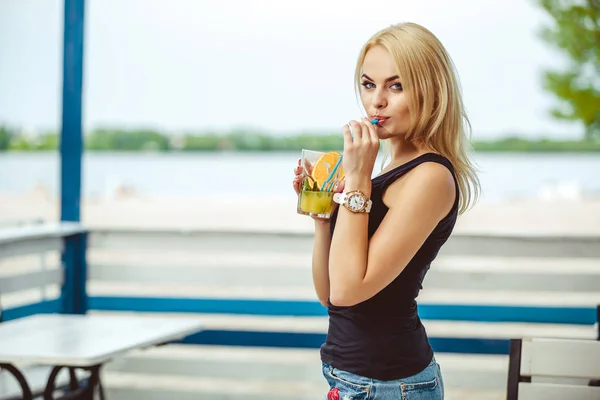 Sarışın kız bir barda bir yaz terasında kokteyl içecekler — Stok fotoğraf
