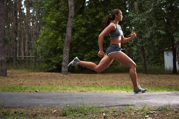 Giovane donna che corre all'aperto in un parco cittadino — Foto Stock