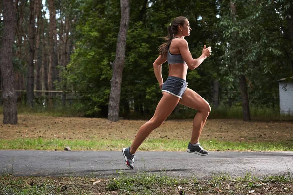 Mujer joven corriendo al aire libre en un parque de la ciudad — Foto de Stock