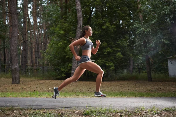 Mujer joven corriendo al aire libre en un parque de la ciudad — Foto de Stock