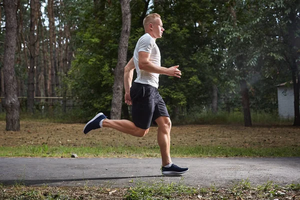 Joven atleta corriendo en el bosque — Foto de Stock