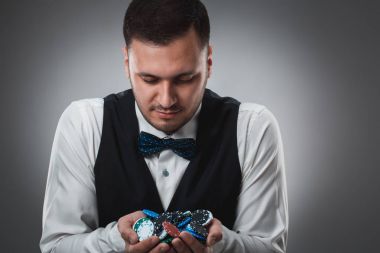 Gömlek ve yelek genç adam poker fişleri, atış studio gösterir
