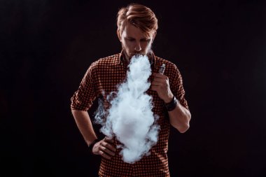 Genç adam elektronik sigara içiyor.