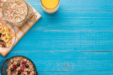 Yulaf ezmesi ve kase ve portakal suyu Kupası'nda meyveleri ile kahvaltı. Metin için yer.