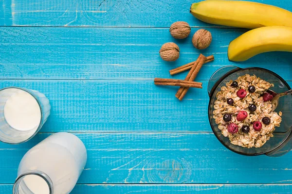 Вівсяна каша з бананом, ківі фруктами, горіхами та медом у мисці з яйцем для здорового сніданку на сільському дерев'яному фоні. вид зверху — стокове фото