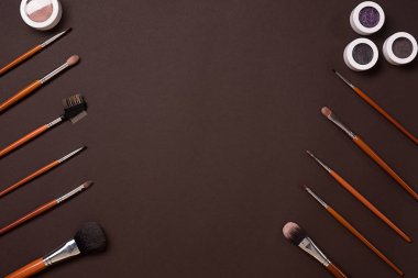Makyaj için göz farı fırçası, yukarıdan görüntüleyin. Kahverengi bir arka plan üzerinde
