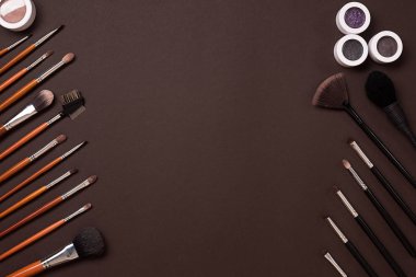 Makyaj için göz farı fırçası, yukarıdan görüntüleyin. Kahverengi bir arka plan üzerinde