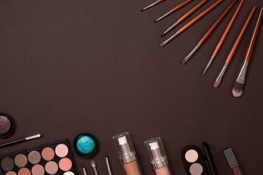 Çeşitli kozmetik ve fırçalar kahverengi zemin üzerine