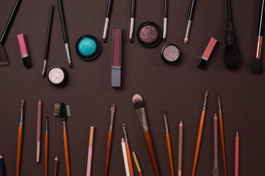 Çeşitli kozmetik ve fırçalar kahverengi zemin üzerine