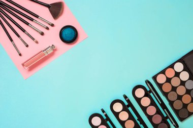 Gerekli kadar olun. Fırçalar, kremler ve gölgeler kavanoz mavi zemin üzerine profesyonel makyaj seti.