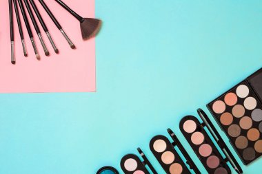 Gerekli kadar olun. Fırçalar, kremler ve gölgeler kavanoz mavi zemin üzerine profesyonel makyaj seti.