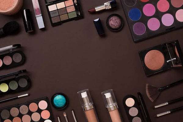 Olika kosmetika och borstar på brun bakgrund — Stockfoto