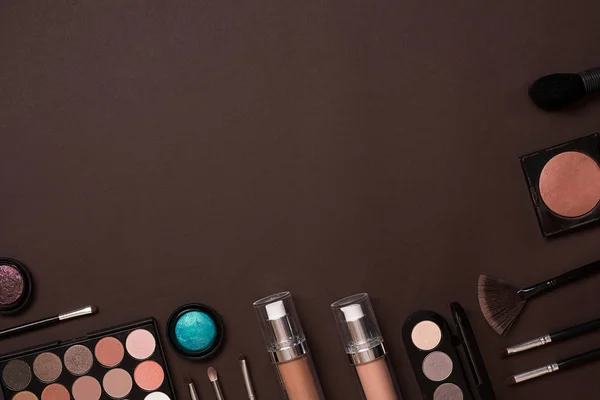 Göra upp essentials. Uppsättning av professionell make up penslar, krämer och skuggor i burkar på mörk bakgrund. — Stockfoto