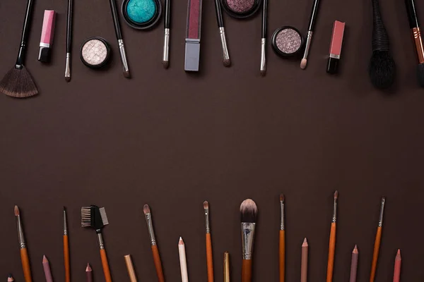 Vários cosméticos e escovas no fundo marrom — Fotografia de Stock
