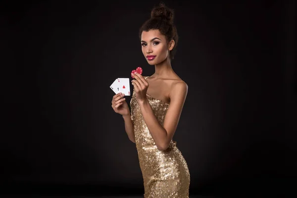 Woman winning - Young woman in a classy gold dress holding two aces and two red chips, a poker of aces card combination. — Stock Photo, Image