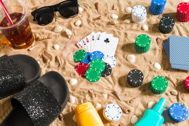 Tatil kavramı - beyaz kum deniz kabuklarını, renkli poker fişleri ve kartları ile kumar. Üstten Görünüm
