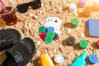 Tatil kavramı - beyaz kum deniz kabuklarını, renkli poker fişleri ve kartları ile kumar. Üstten Görünüm