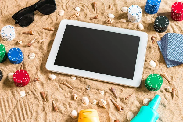 Tatil kavramı - beyaz kum deniz kabuklarını, renkli poker fişleri ve kartları ile kumar. Üstten Görünüm