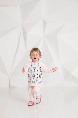 Studio beyaz duvarının yakınında duran yaş çocuk