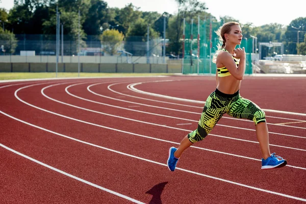 Hermosa joven ejercicio de jogging y correr en pista atlética en el estadio . — Foto de Stock