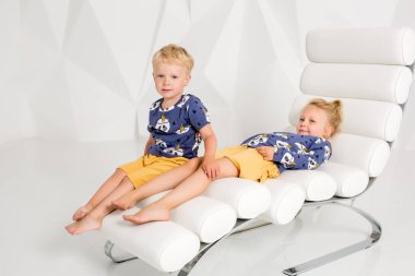 Kız kardeşi ve onun küçük kardeşi beyaz stüdyoda portresi