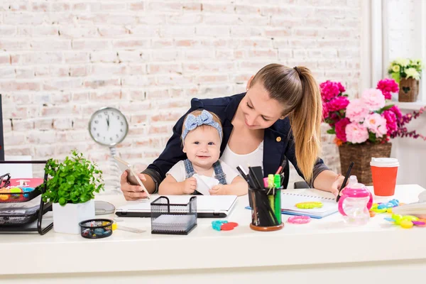 Mãe e mulher de negócios trabalhando com computador portátil em casa e brincando com sua menina . — Fotografia de Stock