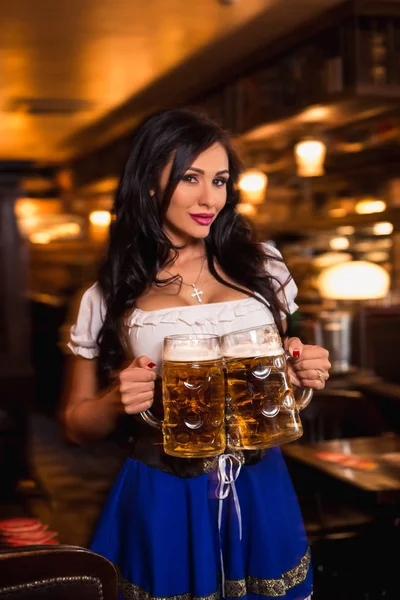 Young waitress brings beer to visitors — Stock Photo, Image