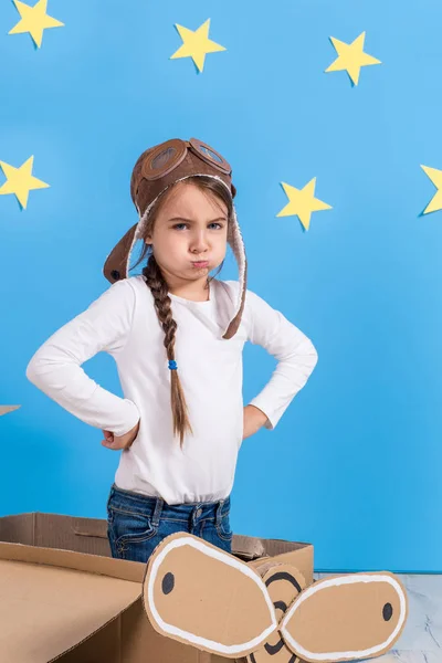 Bambina in costume da pilota sta giocando e sognando di volare sopra le nuvole . — Foto Stock