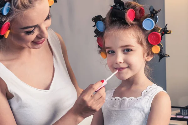 Hübsche Mutter und ihre Tochter amüsieren sich dabei mit Lippenstift — Stockfoto