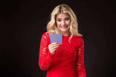 Genç güzel duygusal kadın kartları elinde stüdyoda siyah bir arka plan ile. Poker