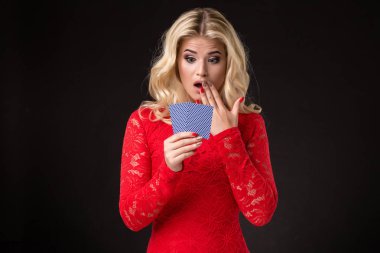 Genç güzel duygusal kadın kartları elinde stüdyoda siyah bir arka plan ile. Poker