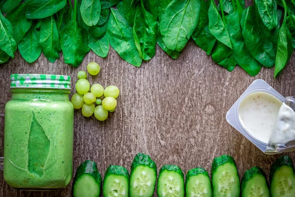 Ispanaklı karşı bir kupa ahşap arka plan üzerinde sağlıklı yeşil smoothie