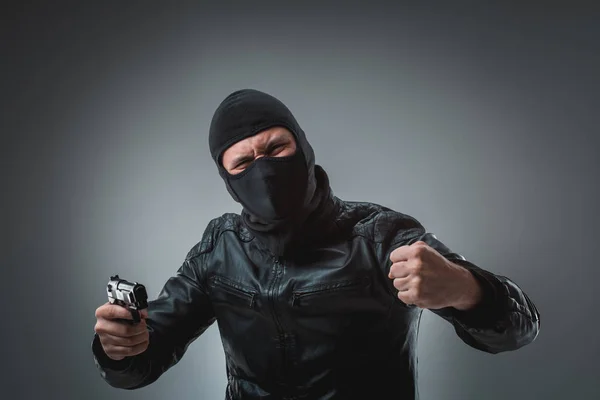 Inbrottstjuv eller terrorism i svart mask skjuta med pistol. — Stockfoto