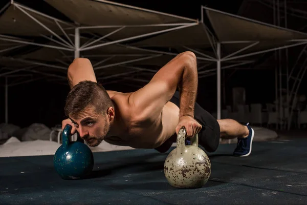 Man doing push-up exercise with dumbbell
