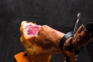 Bütün jamon koyu arka plan üzerinde bir ahşap stand