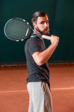 Raket tenis kortunda ile t-shirt yakışıklı genç adam