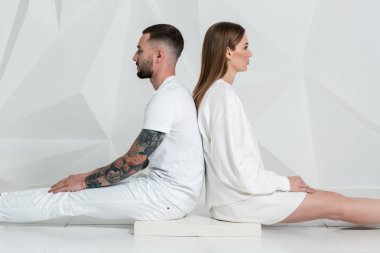 Yakınındaki bir beyaz duvar, erkek ve kadın beyaz giyim rahat Çift.