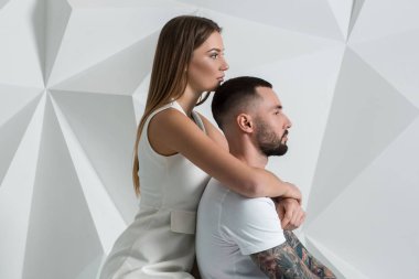 Güzel genç bir çift aşık stüdyoda beyaz arka plan üzerinde poz portresi.