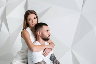 Güzel genç bir çift aşık stüdyoda beyaz arka plan üzerinde poz portresi.