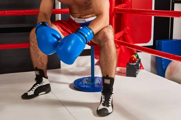 Yüzüğü köşede oturmuş yorgun erkek boxer