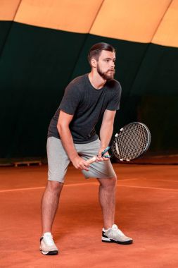 Yakışıklı delikanlı t-shirt holding Tenis raket tenis kortunda