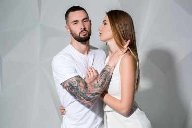Güzel genç bir çift aşık stüdyoda beyaz arka plan üzerinde poz portresi.